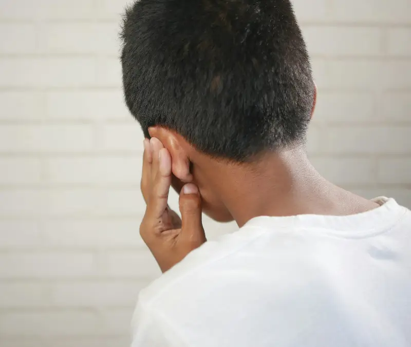 A child is depicted covering their ear, suggesting discomfort or concern.